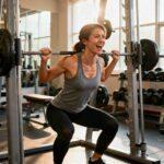 A focused person wearing workout clothes actively exercising in a gym, using gym equipment and showing energy and determination during the workout.